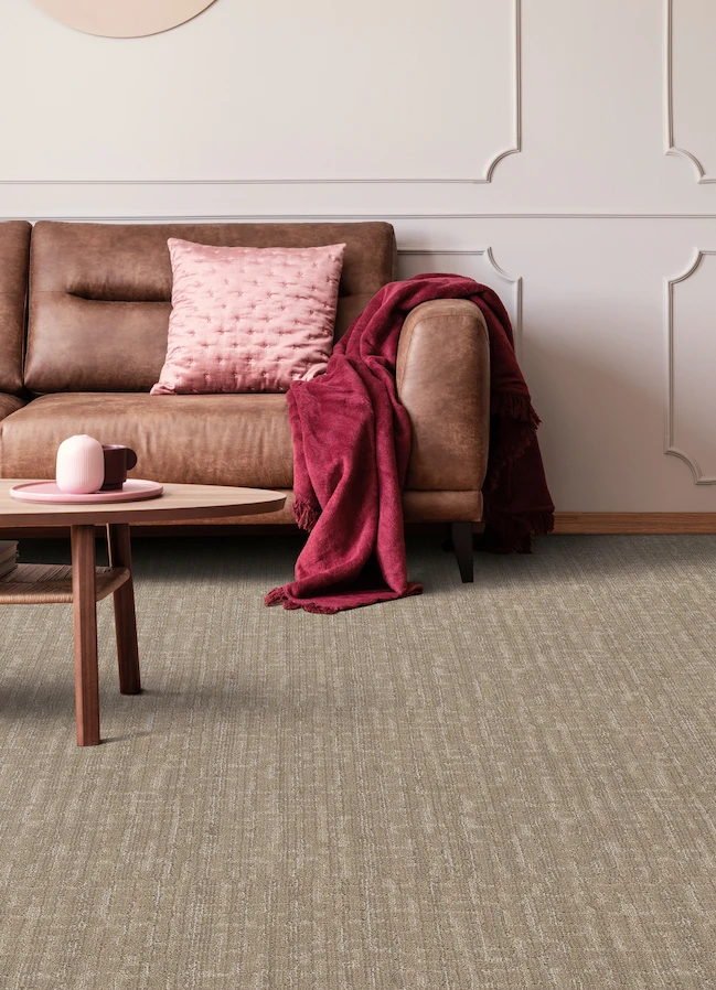 brown textured carpet in a stylish living room with a brown leather couch and pink accents